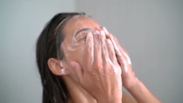 Cilt bakımlı kadın duşta yüzünü yıkıyor cildinde köpüklü sabun var. — Stok video