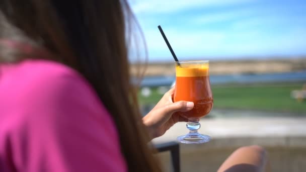 Kobieta relaksująca się w kawiarni na świeżym powietrzu pijąc szklankę zdrowego soku warzywnego — Wideo stockowe