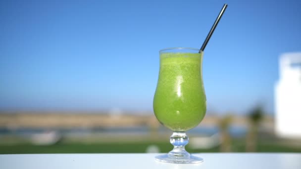 Groene groente smoothie sap glas op restaurant tafel closeup in outdoor cafe — Stockvideo