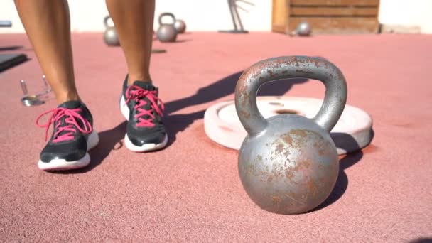 Ginásio crossfit ao ar livre - atleta feminino sapatos de fitness ao lado de kettlebell — Vídeo de Stock