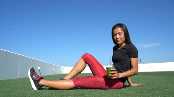 健康的なアジアの女性のランナーはフィットネス運動の前に緑スムージーを飲む — ストック動画