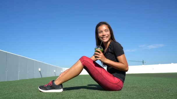 Γυμναστική γυναίκα πίνοντας υγιεινό πράσινο smoothie μετά από ασκήσεις προπόνηση — Αρχείο Βίντεο