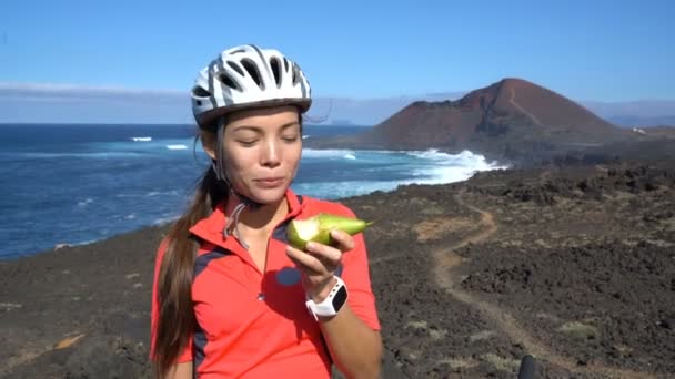 Glad mountainbike kvinna äter hälsosam frukt gör tummen upp — Stockvideo