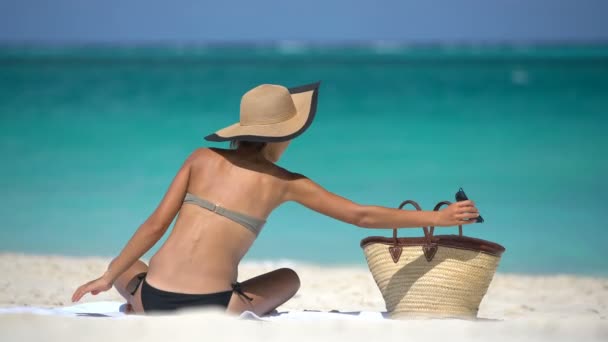 Woman on beach vacation putting on sunglasses enjoying summer vacation — Stock Video