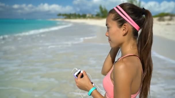 Nő hallgat zenét futás gyakorlása Beach üzembe Eafhones fülébe — Stock videók