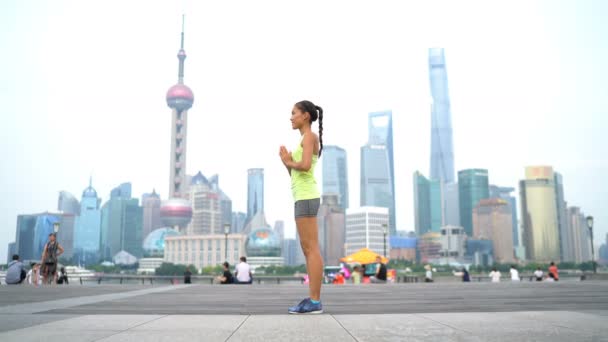 Fitness vrouw doet yoga in Shanghai stad doet zon begroeting — Stockvideo
