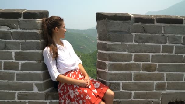 Gran Muralla China viaje- Mujer sentada en la famosa atracción turística — Vídeos de Stock