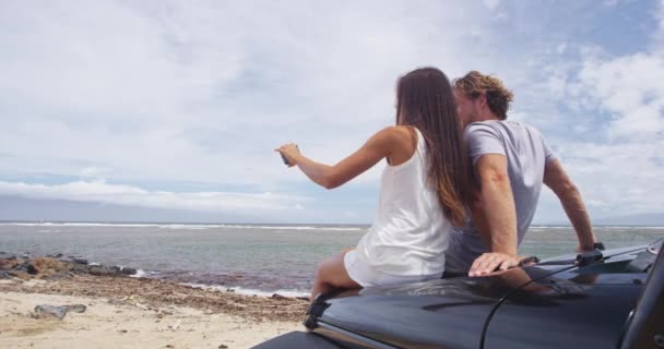 Ζευγάρι λαμβάνοντας Selfie χρησιμοποιώντας Smartphone, ενώ κάθεται σε SUV αυτοκίνητο Ναυάγιο Παραλία — Αρχείο Βίντεο