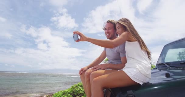 Happy Couple Taking Selfie Using Smartphone On SUV Car At Shipwreck Beach Lanai — стокове відео