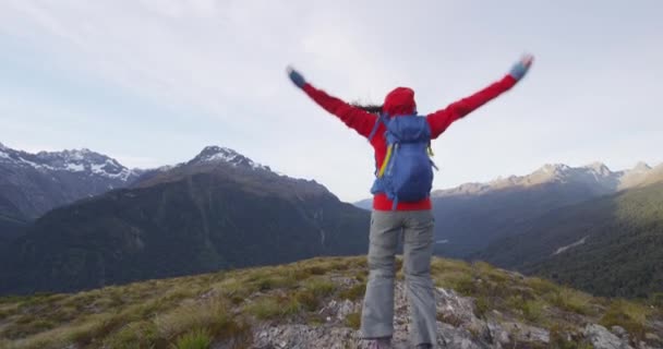 Senderista animando con los brazos extendidos saltando en la montaña — Vídeo de stock