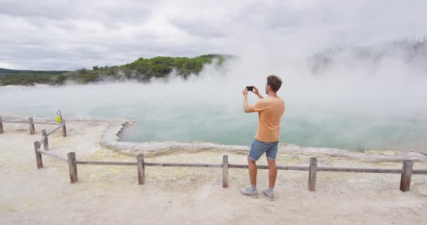 Nowa Zelandia turysta podróżujący biorąc zdjęcie telefonu w Waiotapu Rotorua — Wideo stockowe