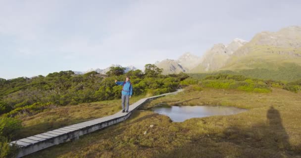 Turysta robi sobie selfie ze smartfonem na promenadzie na torze Routeburn w Nowej Zelandii — Wideo stockowe