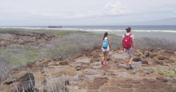 難破船のビーチラナイを歩いている間にバックパックを身に着けている若いカップル — ストック動画