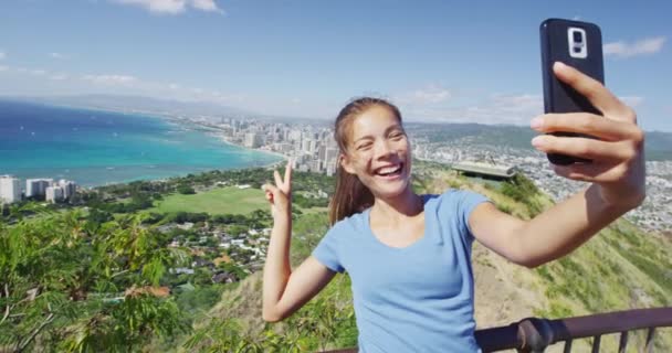 Alegre feminino caminhante tomando selfie contra waikiki praia e honolulu — Vídeo de Stock