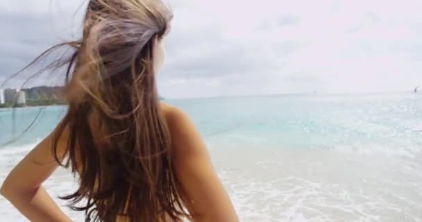 Despreocupado jovem mulher com Windswept cabelo em pé na praia de Waikiki — Vídeo de Stock