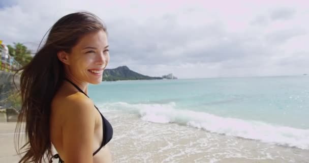 Glad ung kvinna med vindpinat hår står vid Waikiki Beach — Stockvideo