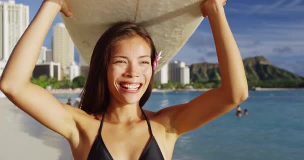 Glad ung kvinna bär surfbräda på huvudet vid Waikiki Beach — Stockvideo