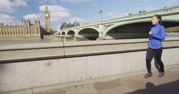 Бегущая женщина бегущая трусцой в Лондоне по реке Темза и Вестминстерскому мосту — стоковое видео