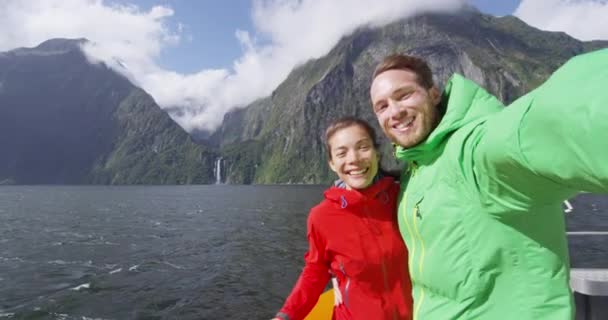 Pareja tomando selfie video en crucero, Milford Sound, Fiordland, Nueva Zelanda — Vídeo de stock
