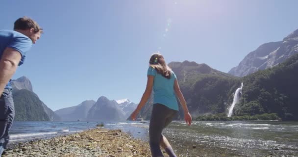 Milford Sound tourist couple hiking in New Zealand enjoying view of Mitre Peak — Stock Video
