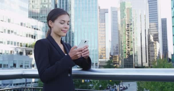 Empresária de mensagens de texto usando o aplicativo no telefone inteligente no centro de Vancouver — Vídeo de Stock