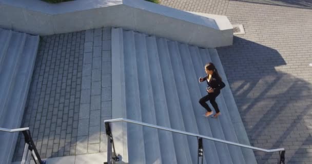 Geschäftsfrau läuft im Anzug mit Kaffee und Telefon die Treppe hoch — Stockvideo