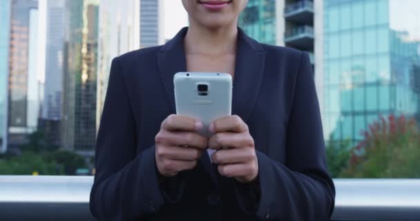 Mulher mãos segurando telefone inteligente no fundo da cidade — Vídeo de Stock