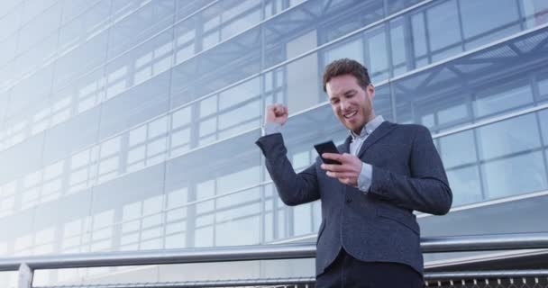 成功と達成-幸せなビジネスマンは、携帯電話を見て応援 — ストック動画