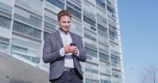 Phone - young businessman using smartphone in smart casual suit by office — Stock Video