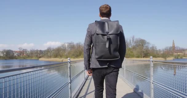 Молодой городской бизнесмен идет на работу в рюкзаке — стоковое видео