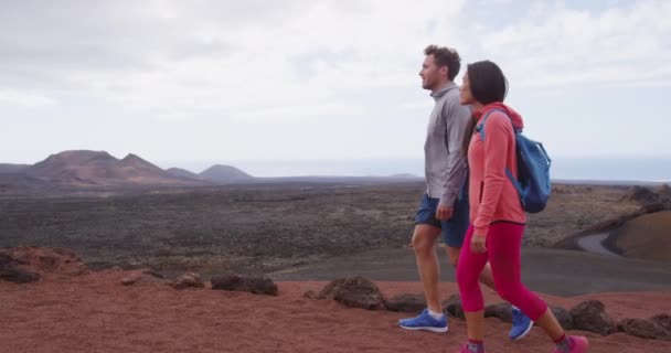 Reizen toeristisch paar wandelen op vakantie in vulkaan bergen van Lanzarote — Stockvideo