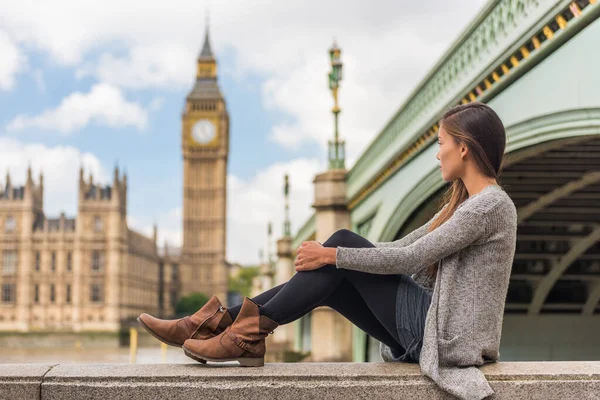 London young woman relaxing pensive thinking alone at Big Ben tower in urban Europe city. Asian girl lonely sad or depressed sitting outdoors in the city, England, UK, Great Britain — Stock Photo, Image