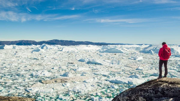 Viaje na natureza da paisagem ártica com icebergs - Explorador turístico da Groenlândia - pessoa turística olhando para uma vista incrível do fiorde de gelo da Groenlândia - vídeo aéreo. Homem por gelo e iceberg em Ilulissat — Fotografia de Stock