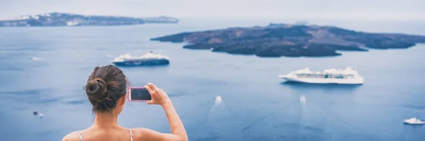 Turista de viajes tomando fotos de vacaciones con teléfono de cruceros en el mar Mediterráneo en Santorini, Grecia. Europa destino de vacaciones banner panorama —  Fotos de Stock