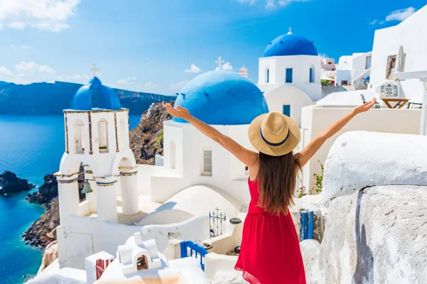 ヨーロッパ旅行幸せな休暇の女性。サントリーニクルーズホリデー、夏のヨーロッパの目的地で自由に腕を開いて楽しんでいる女の子の観光客。赤いドレスと帽子の人 — ストック写真