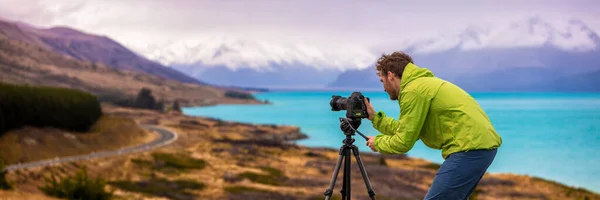 Reisefotograf Mann macht Naturvideo von Berglandschaft auf Peters Aussichtspunkt, Neuseeland Banner. Touristiker professioneller Videofilmer im Abenteuerurlaub schießt Slr-Kamera auf Stativ — Stockfoto