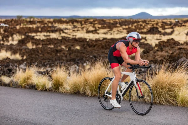 Triathlon professional cyclist man cycling road racing bike in time trial helmet and compression tri suit in Hawaii landscape for Kailua-Kona ironman. Triathlete biking in nature — Stock Photo, Image