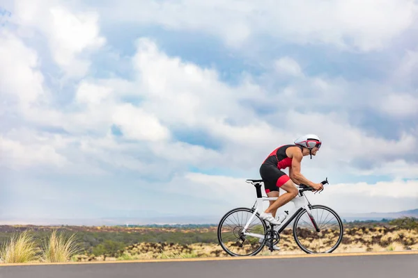 Triatlón ciclista ciclismo en bicicleta de carretera en la competición de Ironman contra el tiempo en el paisaje de fondo de la naturaleza. Copiar espacio por encima del atleta en el cielo — Foto de Stock