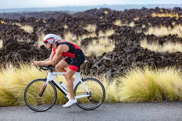 Ciclismo triatleta hombre ciclismo bicicleta de carretera bajo la lluvia durante la carrera de triatlón en Hawaii paisaje de la naturaleza. Entrenamiento de resistencia de entrenamiento de deportistas al aire libre en Kailua-Kona, Big Island, Hawaii, Estados Unidos — Foto de Stock