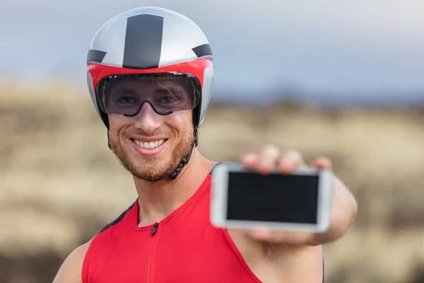 Telefon sportovní aplikace triatlon muž cyklistika silniční kola- triatlonista pomocí aplikací smartphone map během cyklistiky. Přizpůsobit mužský cyklista na profesionální triatlonové kolo pomocí aplikace mobilního telefonu — Stock fotografie