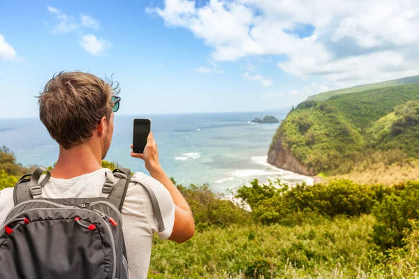 Viajar hombre turístico en Hawaii playa EE.UU. vacaciones tomar una foto con el dispositivo de teléfono móvil de fondo montañas paisaje oceánico. Isla Grande, Hawai. —  Fotos de Stock