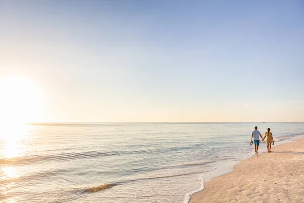 Vacaciones relajantes en la playa - turistas de viaje pareja caminando en la playa al atardecer paisaje de fondo. Destino vacaciones de verano —  Fotos de Stock