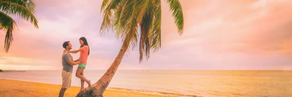 Paar romantische Kurzurlaube Flitterwochen reisen Urlaub Panorama-Banner. Zwei verliebte Touristen umarmen sich bei Sonnenuntergang vor Palmen — Stockfoto