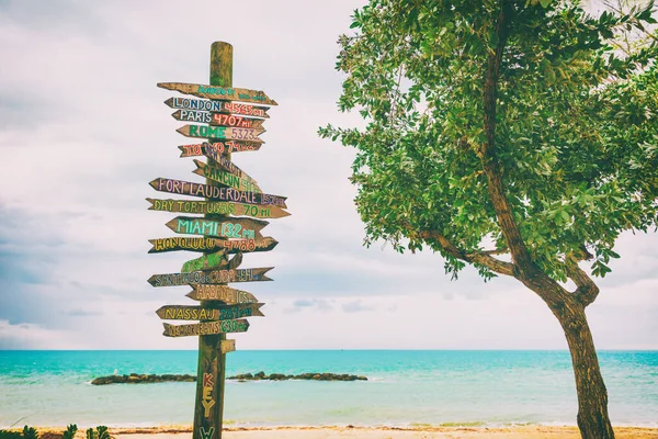 Key West beliebte Touristenattraktion am Florida Zachary Beach, hölzerne Hinweisschilder, die Entfernungen zu berühmten Orten der Welt anzeigen — Stockfoto