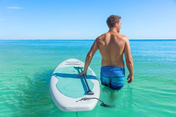 ターコイズブルーのカリブ海の海で泳ぐパドルボードのフィットネスマン — ストック写真