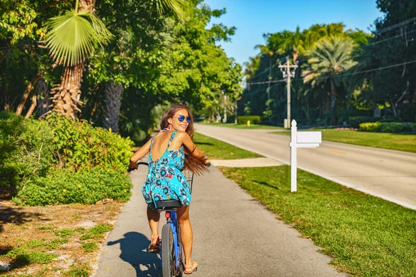 Bicicleta menina ciclismo recreativo turista feliz olhando para trás feliz se divertindo no passeio de bicicleta casual no destino de férias de verão — Fotografia de Stock