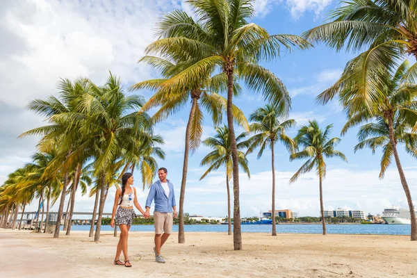 Estilo de vida de pessoas de Miami - casal andando de mãos dadas falando curtindo andar na praia com palmeiras. Destino de viagem Florida — Fotografia de Stock