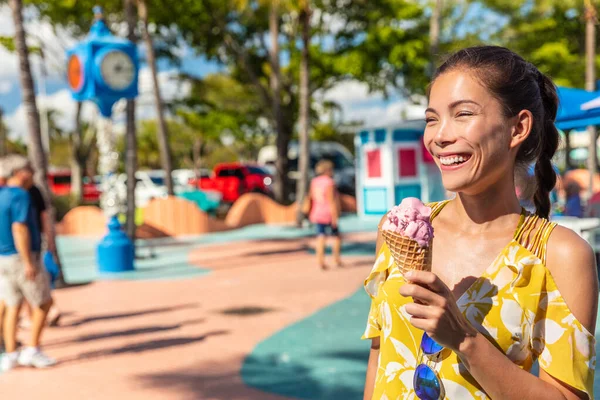 Glace manger asiatique fille marche dehors sur la plage boardwalk rire heureux avec gaufre cône de cerise congelé sorbet dessert — Photo