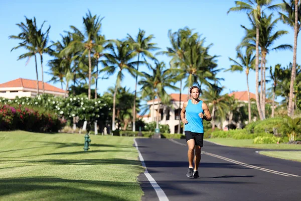 Coureur homme sport fitness athlète coureur jogging sur la route résidentielle dans la ville tropicale. Entraînement d'été entraînement cardio en plein air — Photo