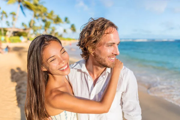 Miesiąc miodowy na plaży para zakochana w przytulaniu. Młodzi, międzyrasowi kochankowie relaksujący się na plaży o zachodzie słońca — Zdjęcie stockowe